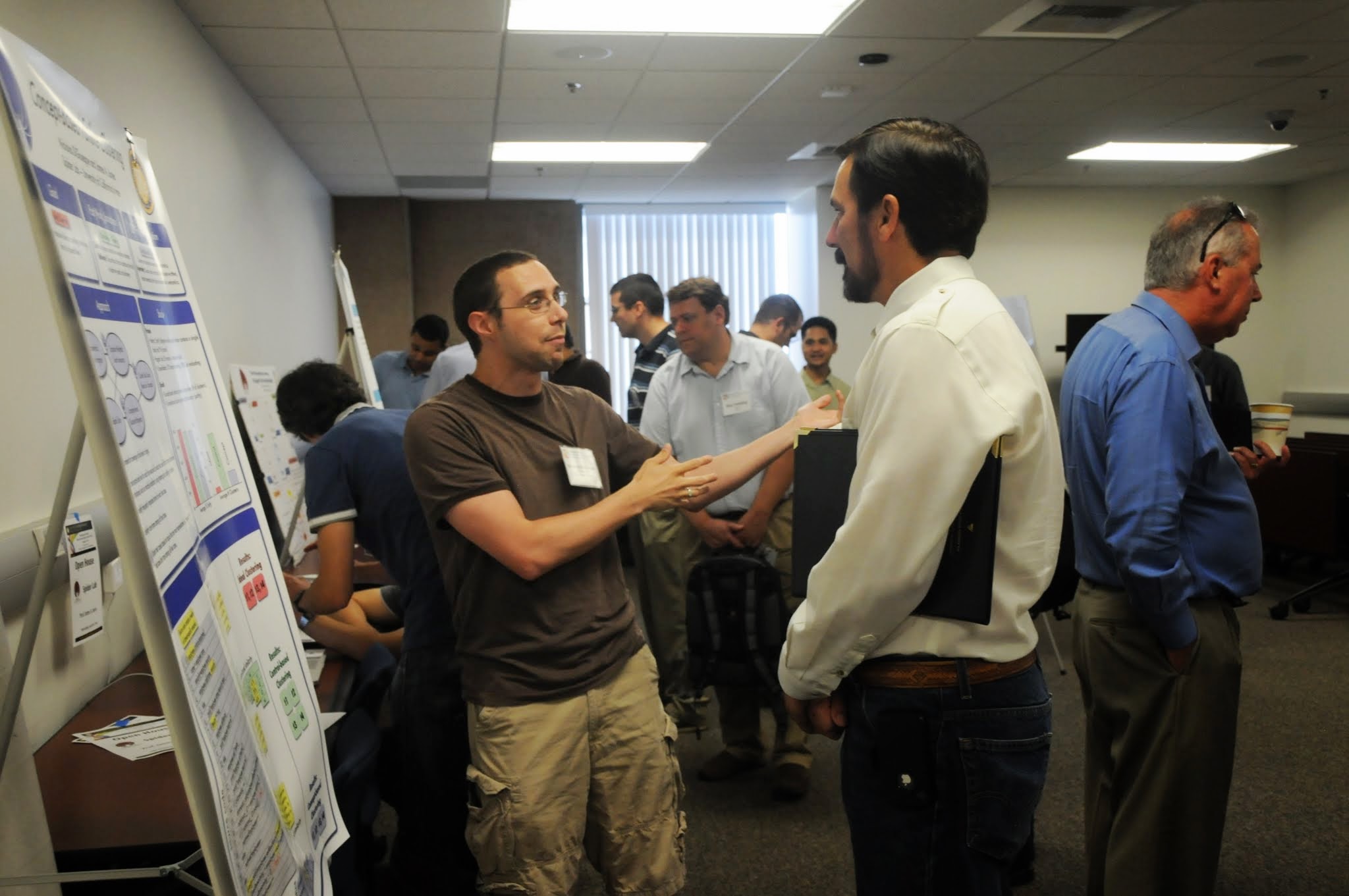 Ph.D. student Nicholas DiGiuseppe presents poster to industry attendees at Forum Open House.