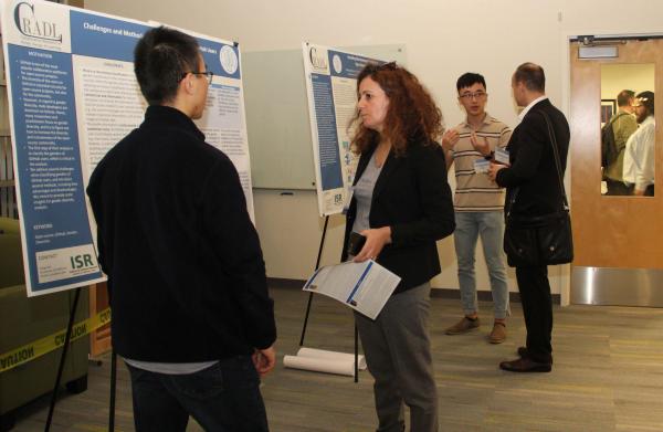Ph.D. students Yang Yue and Zhendong Wang present their research project posters to SuCSES attendees.