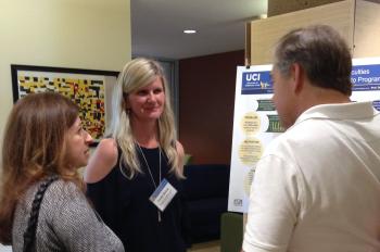 Visiting PhD student Yorah Bosse, center, presents her research poster to industry attendees.